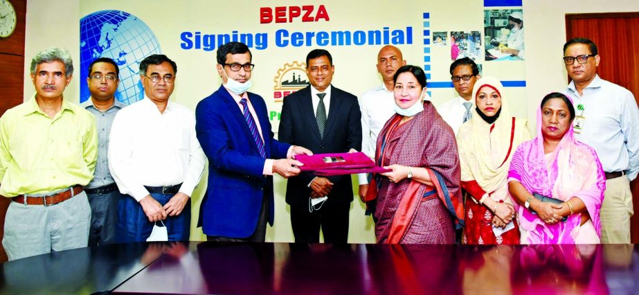 Md. Mahmudul Hossain Khan, Member (Investment Promotion) of BEPZA and Parveen Mahmud, Managing Director of Shasha Garments Limited, exchanging document after signing an agreement at BEPZA complex in the capital on Tuesday. Under the deal, the company is g