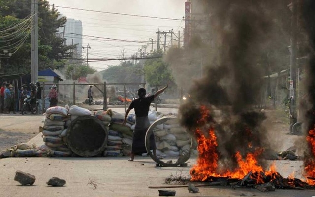 A demonstrator gestures near a barricade during a protest against the military coup in Mandalay, Myanmar March 22, 2021.