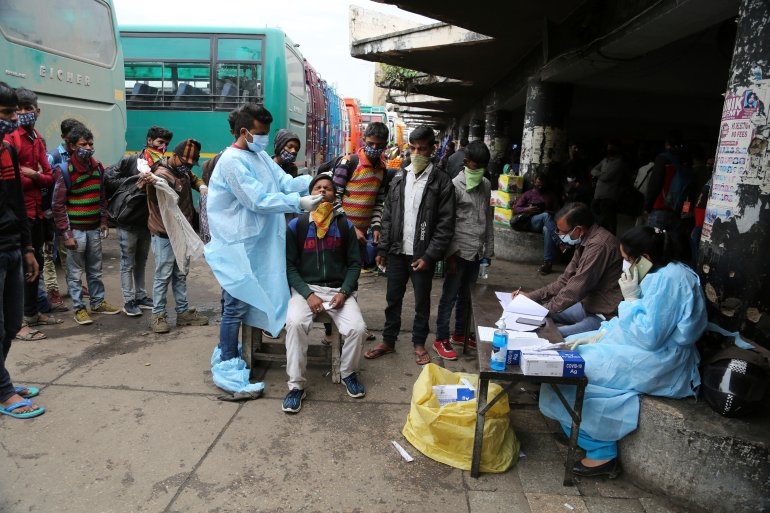 A health worker takes a nasal swab from a migrant worker to test for Covid at a bus station in Jammu, Indian-administered Kashmir.