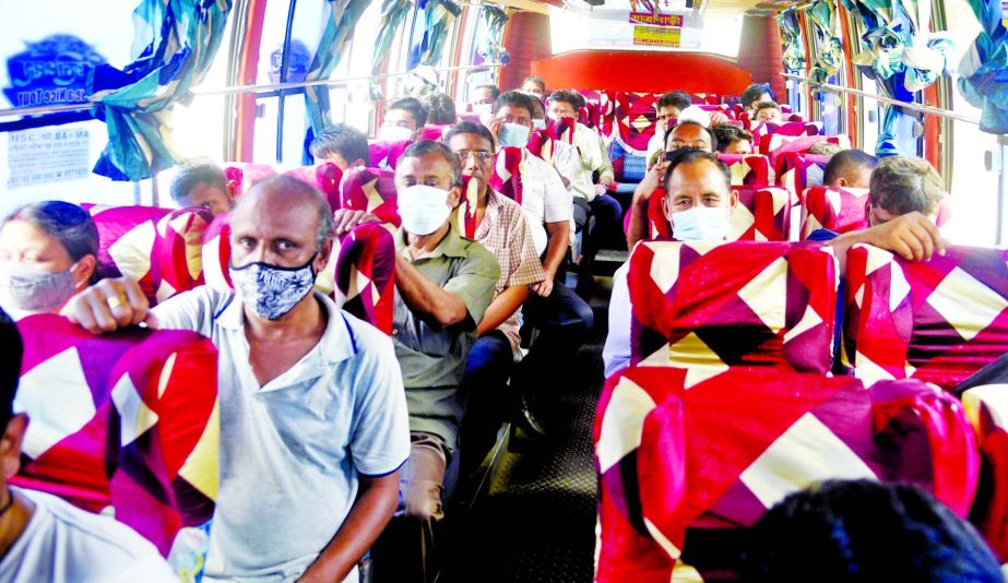 Passengers wear masks to protect themselves from corona infection during their bus trip in the capital. This photo was taken from Topkhana road on Tuesday.