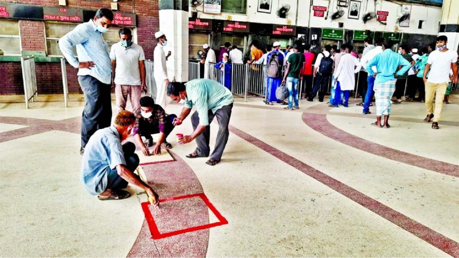 Painters draw squares in front of a ticket counter at Kamlapur Railway Station in Dhaka on Tuesday in bid to enforce physical distancing rules amid a new Covid-19 wave in the country.