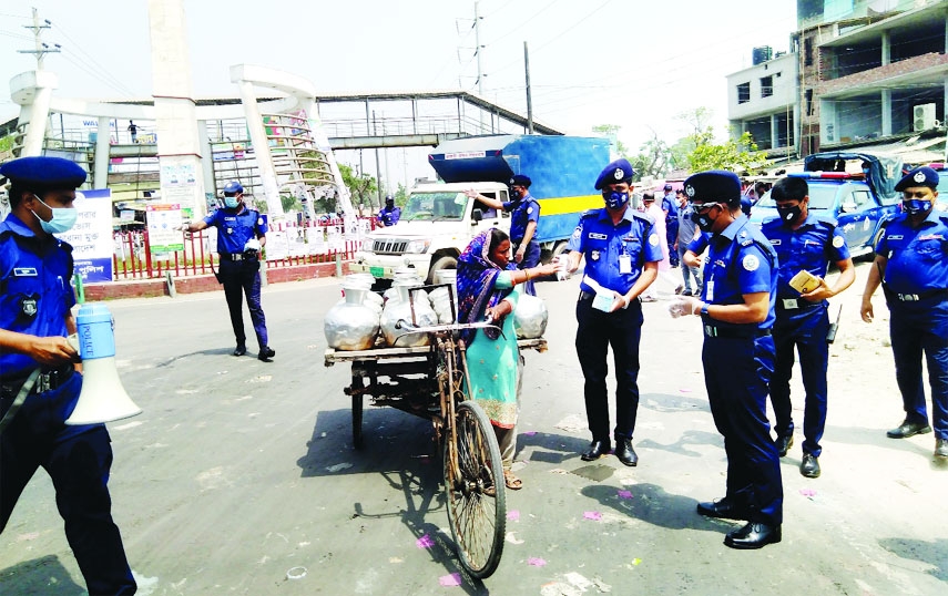 Patuakhali SP Mohammad Shahidullah, PPM leads a team of police in the district to make the people aware of maintaining health guidelines and distributes masks among the residences free of cost on Thursday.