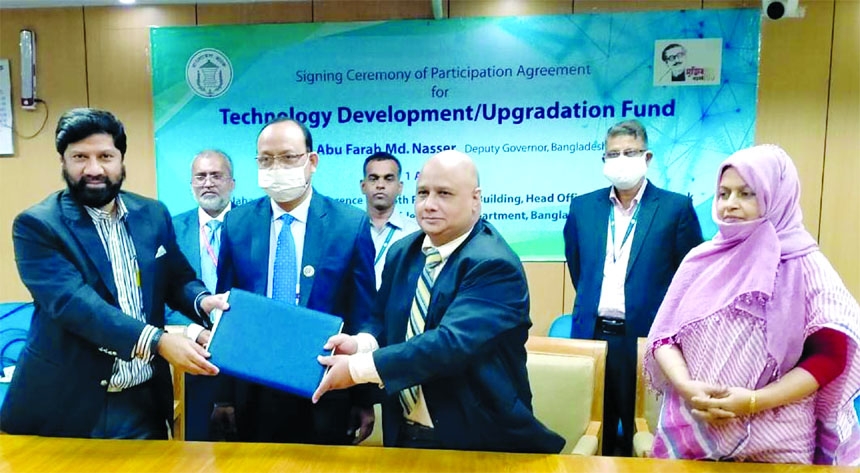 Khondoker Rashed Maqsood, Managing Director & CEO of Standard Bank Limited and Khandaker Morshed Millat, GM of Bangladesh Bank (BB), exchanging documents after signing an agreement to provide loans as part of the refinancing fund set up by BB for technolo