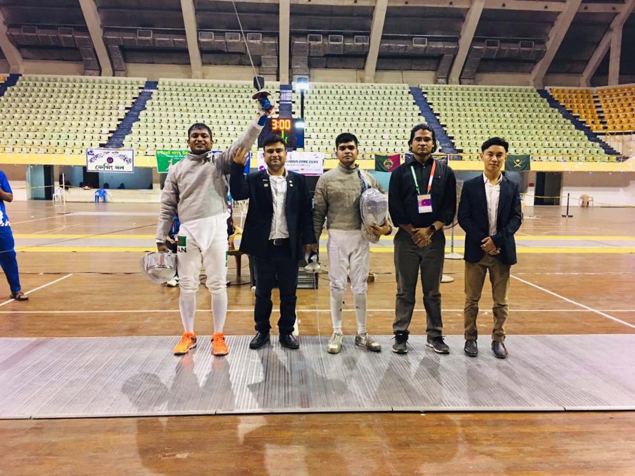 Iftekharul Islam (left) of Bangladesh Ansar & VDP, celebrating after wining his third gold medal in Fencing in the Bangabandhu 9th Bangladesh Games at the Shaheed Suhrawardy Indoor Stadium in the city's Mirpur on Wednesday night.