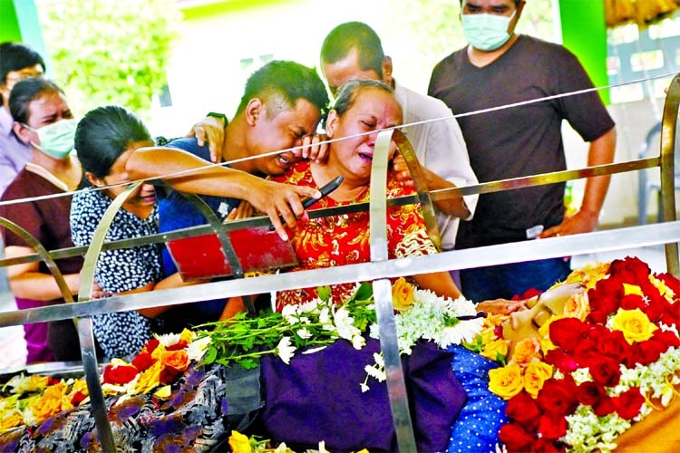 Relatives cry as they look at the body of Su Su Kyi, who was shot in a car on her way home from work at South Korea's Shinhan Bank, during her funeral at Yayway cemetery in Yangon, Myanmar on Friday.