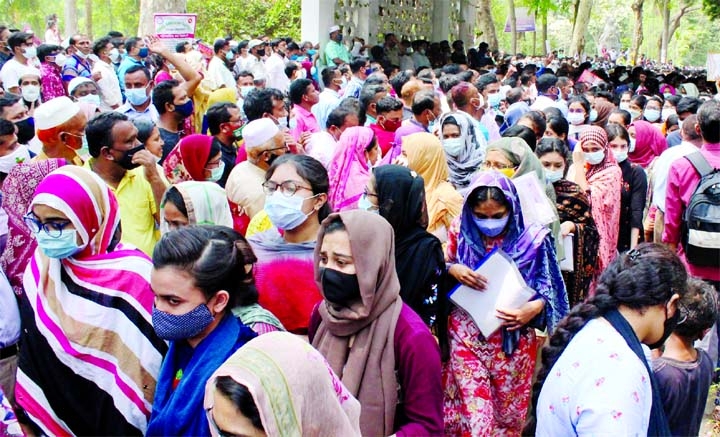 Candidates and their guardians are seen gathering in huge numbers in front of an exam centre before the MBBS admission test at Dhaka University in the capital on Friday amid a record surge in coronavirus cases.
