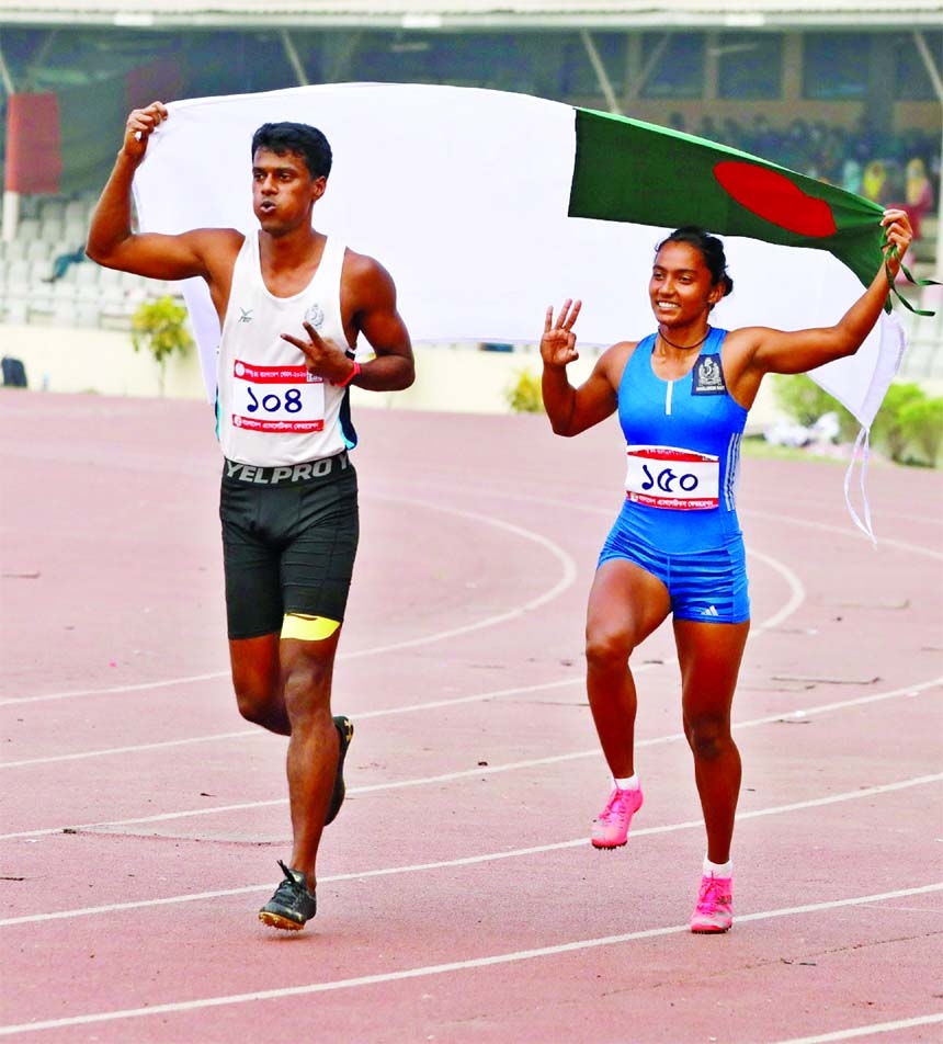 Mohammad Ismail (left) and Shirin Akhter of the Bangladesh Navy celebrate after winning the gold medal in the 100m sprint at Bangabandhu National Stadium(BNS) on Saturday.