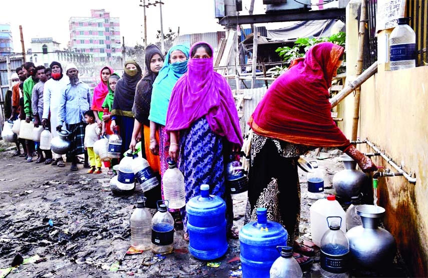 Local people stand in a long queue to collect water from taps as there was acute scarcity of drinking water at Jatrabari area in the capital on Saturday.
