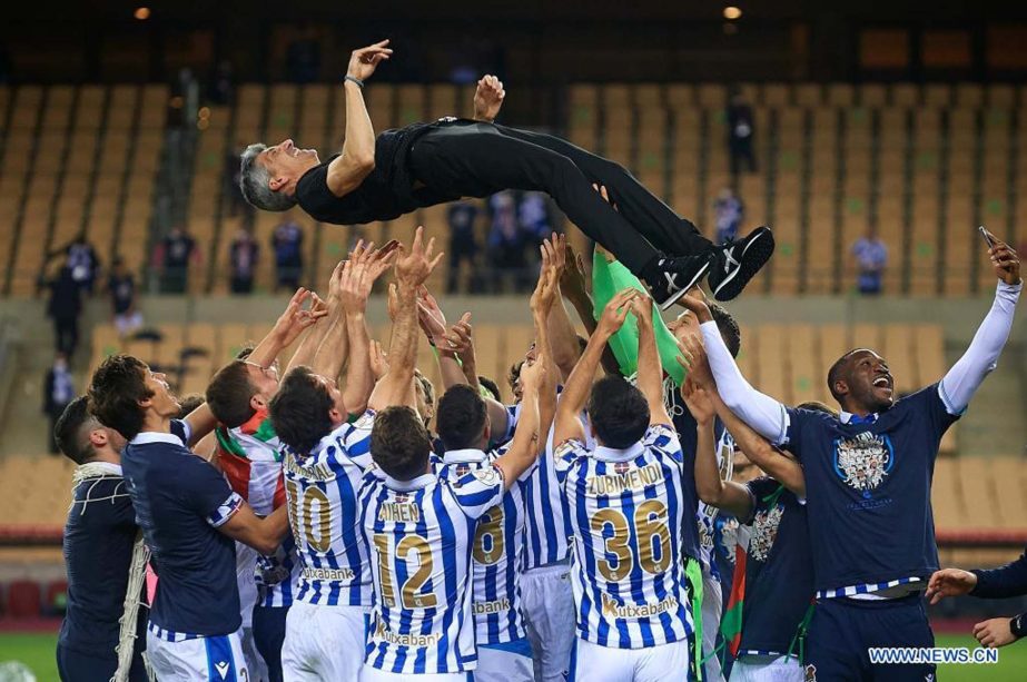 Players of Real Sociedad celebrate the victory by throwing head coach Imanol Alguacil after the Spanish King's Cup final match between Athletic Club Bilbao and Real Sociedad in Seville, Spain on Saturday.