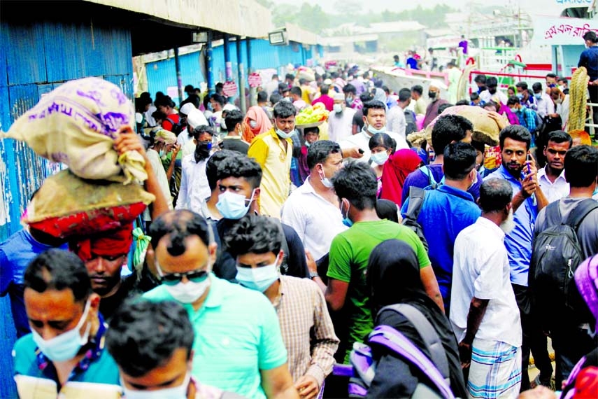 People start leaving Dhaka city boarding different types of vehicles without following social distancing rules as a the government declared 7-day lockdown in order to contain corona virus infection. This photo was taken from Mawa Ghat Terminal on Sunday.