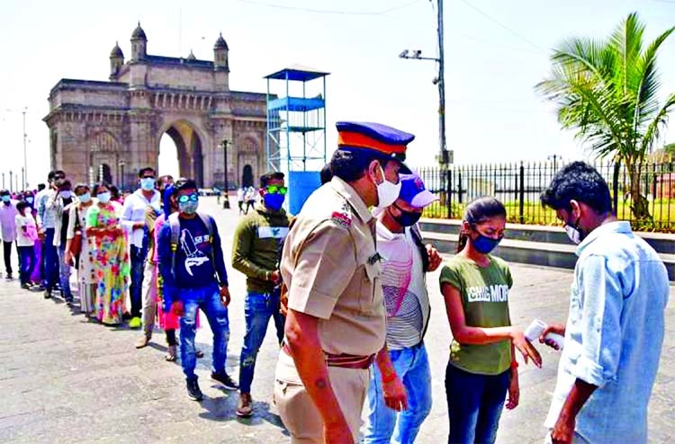 People queue up as they wait for their turn to undergo a mandatory COVID-19 test before entering the Getaway of India in Mumbai.