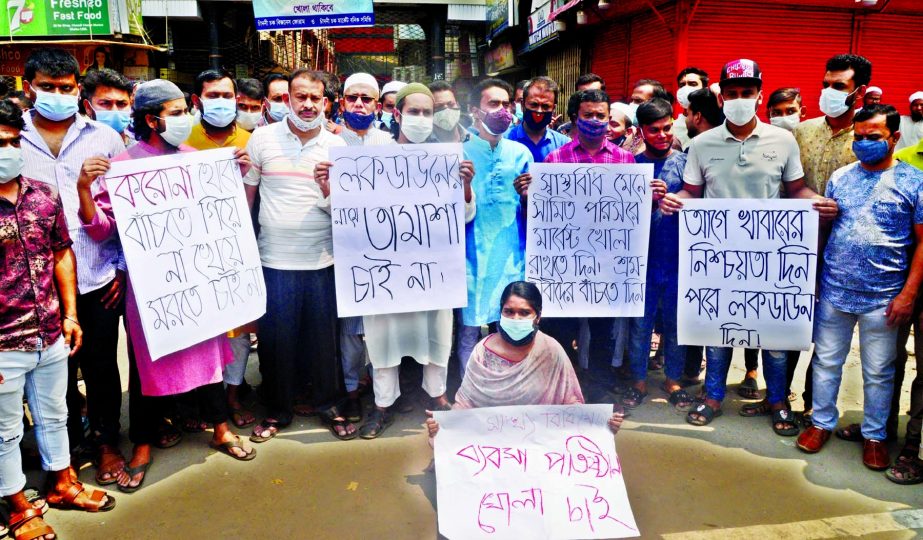 Traders stage a sit-in in front of Chadnichawk market in the city on Tuesday with a call to open market in limited scale following health guidelines.