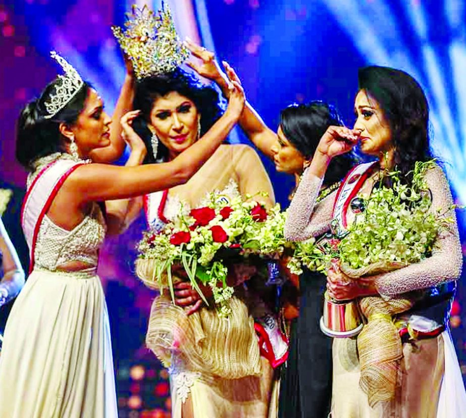 In the photograph, winner of Mrs Sri Lanka 2020 Caroline Jurie (L) removes the crown of 2021 winner Pushpika de Silva (C) as she is disqualified by the jurie over the accusation of being divorced, at a beauty pageant for married women in Colombo.