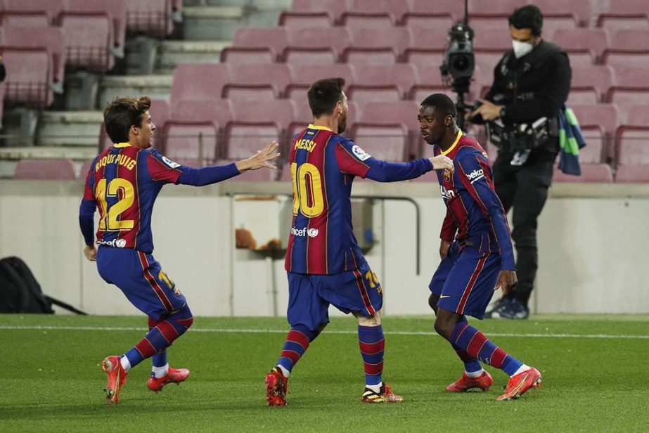 Barcelona's Ousmane Dembele (right) celebrates with Lionel Messi and Riqui Puig after scoring the first goal against Real Valladolid on Monday.