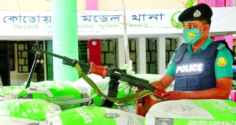A policeman stands guard with an LMG at Kotwali Model Police Station in Sylhet city on Thursday in the wake of vandalism and arson attacks by Hefazat-e Islam in parts of Bangladesh.