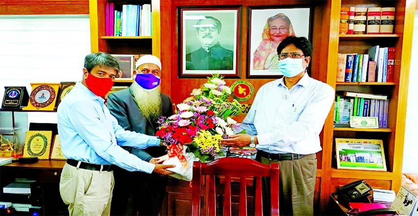Muzaffar Ahmed, President of the Institute of Chartered Secretaries of Bangladesh (ICSB), presenting flower Dr Md Jafar Uddin, Senior Secretary of the Commerce Ministry, for his promotion at the latter's office at Secretariat on Thursday. Md Selim Reza,