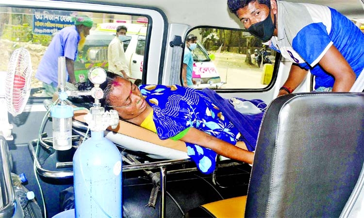 With oxygen support, an elderly woman lies inside an ambulance in front of the Chattogram Medical College and Hospital yesterday to get admitted there.