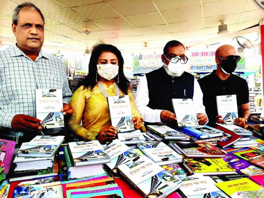 Liberation War Affairs Minister AKM Mozammel Haque, among others, holds the copies of a book titled 'Du Chokhe Padma Setu' edited by Helena Zahangir at its cover unwrapping ceremony on the book fair premises in the city's Suhrawardy Udyan on Saturday.