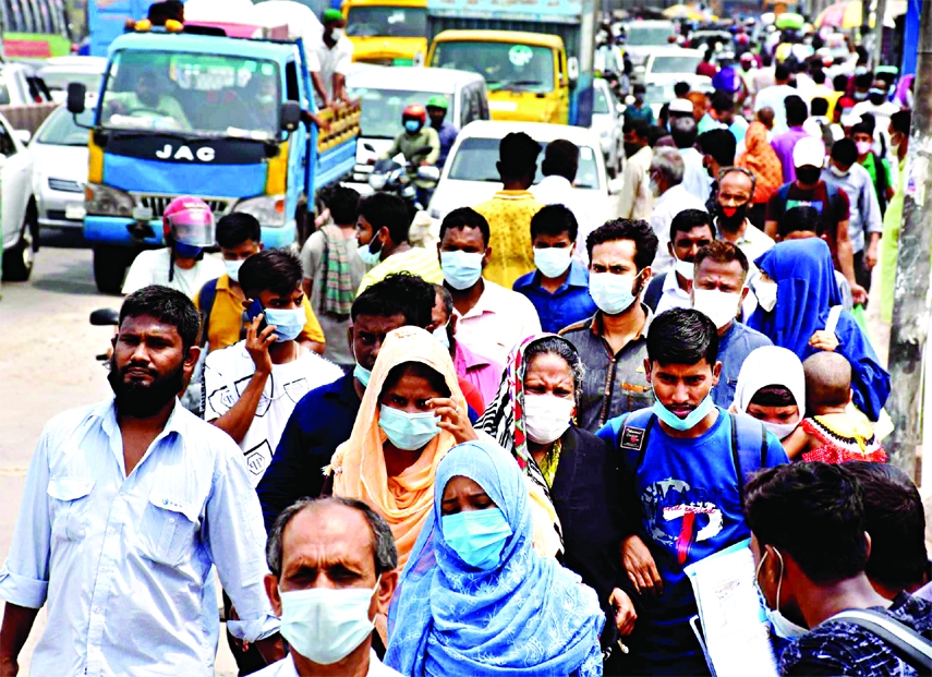 People march towards the capital's Gabtoli Bus terminal on Saturday on their way to village home ahead of the second phase of country-wide lockdown starting from 14th April.