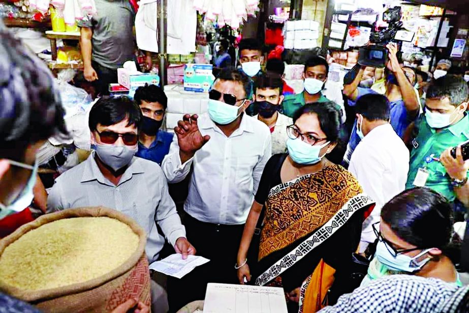 A team from Directorate of National Consumer Rights Protection conducts a drive at a shop in the capital's Karwan Bazar on Saturday amid price hike of essential commodities in the market.