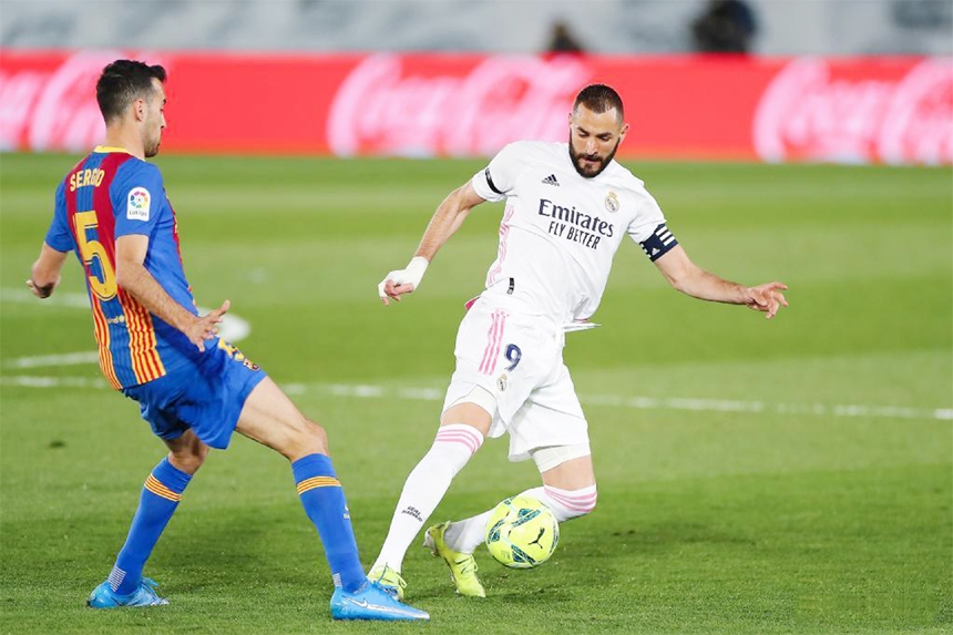 Real Madrid's Karim Benzema (right) vies with Barcelona's Sergio Busques during a Spanish league football match between Real Madrid and FC Barcelona in Madrid, Spain on Saturday.