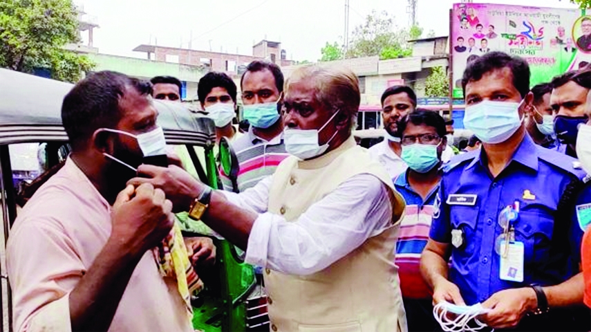 Advocate Abdul Majid Photo, Chairman of Upazila Parishad in Saturia, Manikganj distributes masks among the people of the upazilla at Saturia bus stand and market area on Saturday.