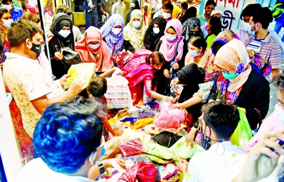 Customers throng New market in the capital without following social distancing norms on Tuesday ahead of strict lockdown beginning from Wednesday.