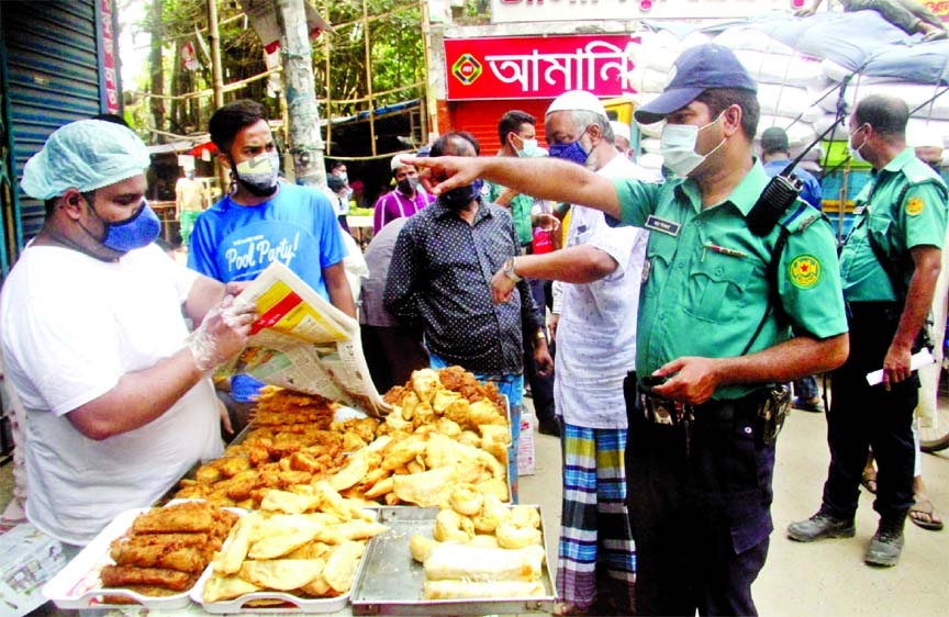 Police prevent a trader from selling Iftar items on the street of Old Dhaka's Chawk Bazar on the second day of Ramzan amid a coronavirus lockdown on Thursday