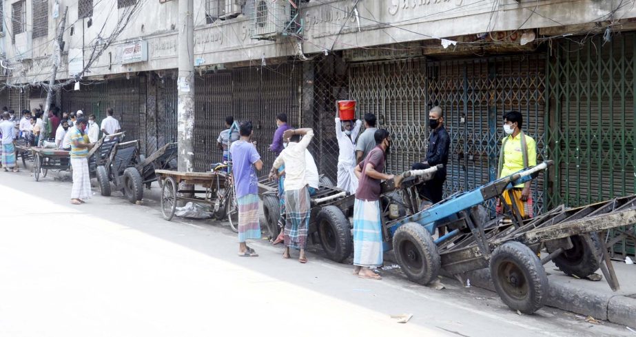 Day-labourers seen to wait with their push carts aiming to earn. The snap was taken from in front of Nayabazar paper selling market in the city on Saturday.