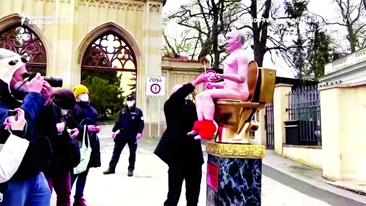 Czech protesters installed an effigy of Russian President Vladimir Putin depicting him naked and sat on a mock toilet outside the Russian embassy in Prague on Friday.