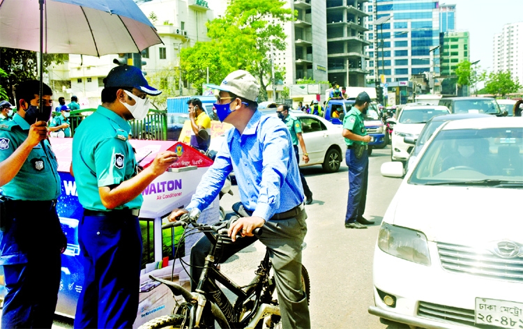 Police halts a cyclist near a check post at Kakrail intersection on Sunday as he came out amid strict lockdown on the 5th day.