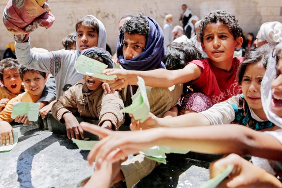 Yemenis present documents in order to receive food rations provided by a local charity in the capital Sanaa.