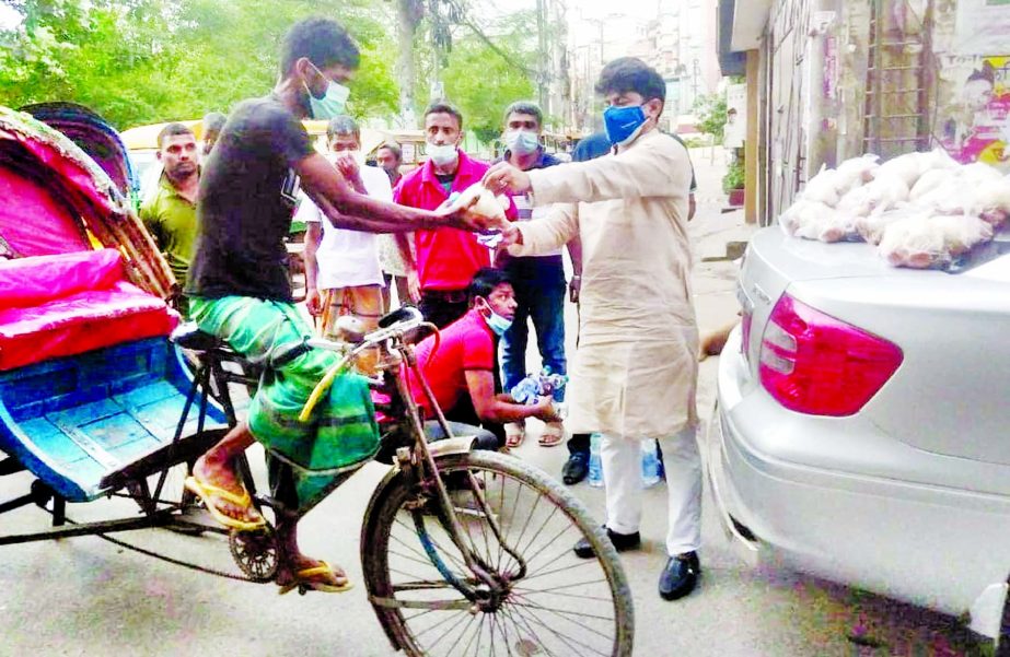 Councilor of 26 No. Ward of DSCC Hasibur Rahman Manik distributes iftar items among the passers-by at Lalbagh area in the city on Tuesday.