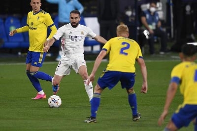 Real Madrid's Dani Carvajal (center) vies for the ball with Cadiz defenders during the Spanish La Liga soccer match at the Ramon Carranza stadium in Cadiz, Spain on Wednesday. Real Madrid won 3-0.