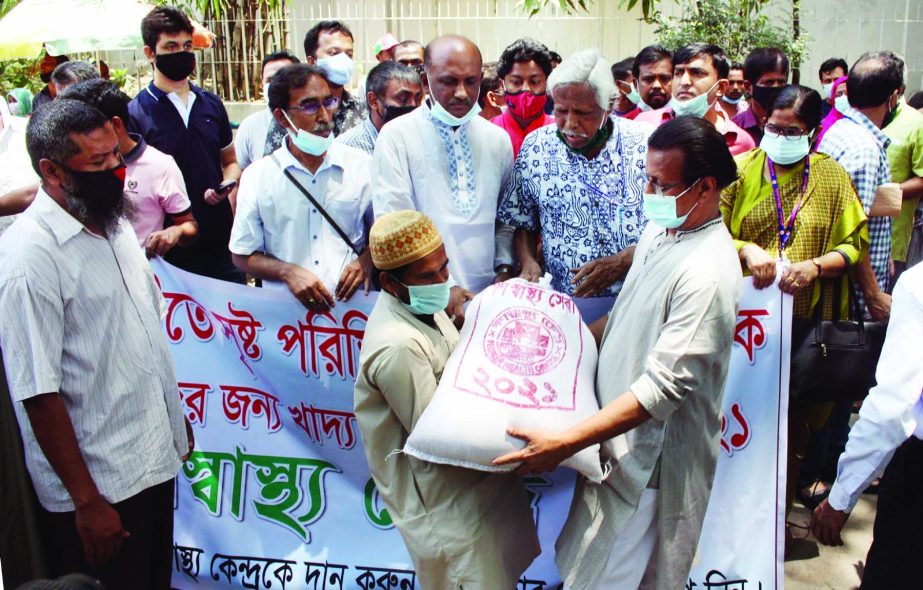 Trustee of Ganoswasthya Kendra Dr. Zafrullah Chowdhury distributes foodstuff among hawkers, workers and unemployed journalists in front of Ganoswasthya Kendra Hospital in the city on Saturday.