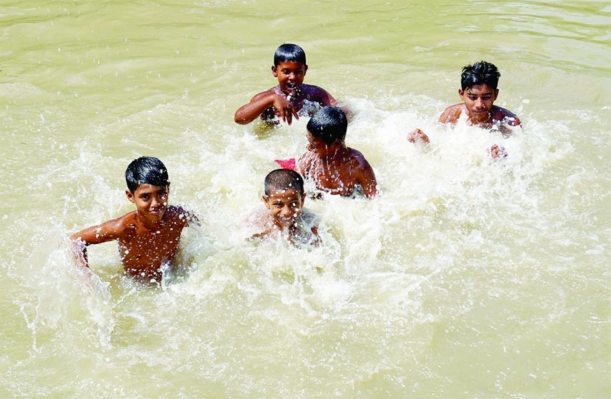 Children are rejoicing in pond water to get relief from the ongoing heat-wave of this summer blowing all over the country on Sunday. The photo was taken from Bererbari of Dhunat upazilla.