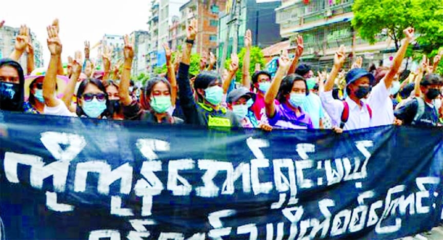 Anti-coup protesters flash the three-finger salute, holding banner read " Yangon Strike will defeat all enemies" during a demonstration against the military coup in Yangon, Myanmar.