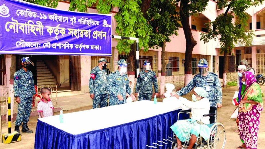 Bangladesh Navy distributes foodstuff among the destitute on the premises of Kurmitola High School and College in the city's Khilkhet on Wednesday.