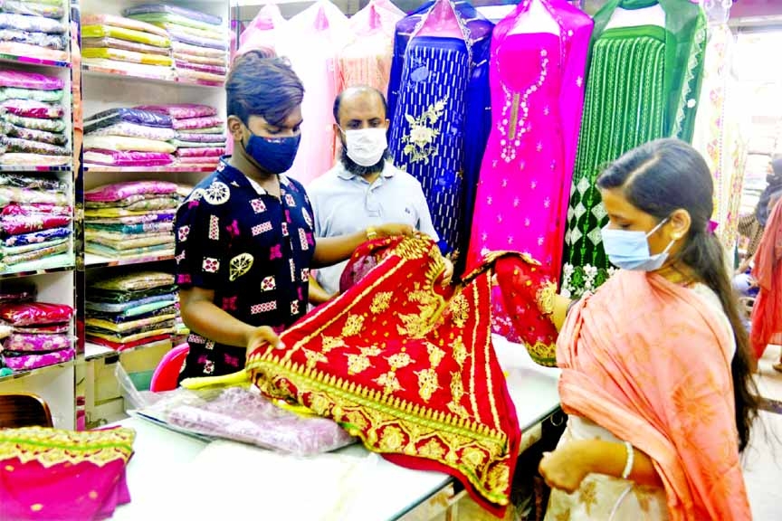 A woman looks for her desired attire ahead of the Eid-ul-Fitr. The photo was taken from Paltan China Town Shopping Centre in the capital on Thursday.
