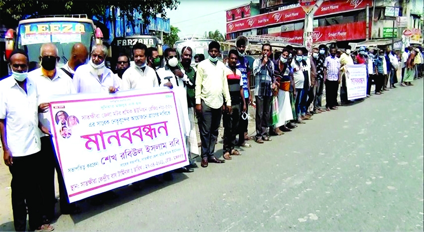 Members of Satkhira district Bus-Minibus Workers' Union hold a human chain at Satkhira central bus terminal on Tuesday demanding government's food assistance as they have no work during the ongoing lockdown.