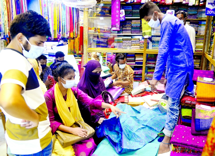 Customers look for their dress as part of shopping ahead of Eid-ul-Fitr during lockdown at Gausia Market in the capital on Friday.