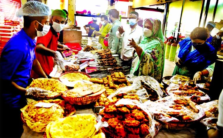 People buy iftar items from a stall in the capital's Bailey Road, where numerous shops are selling an array of non-traditional items for quite a few years now. The snap was taken on Friday afternoon.