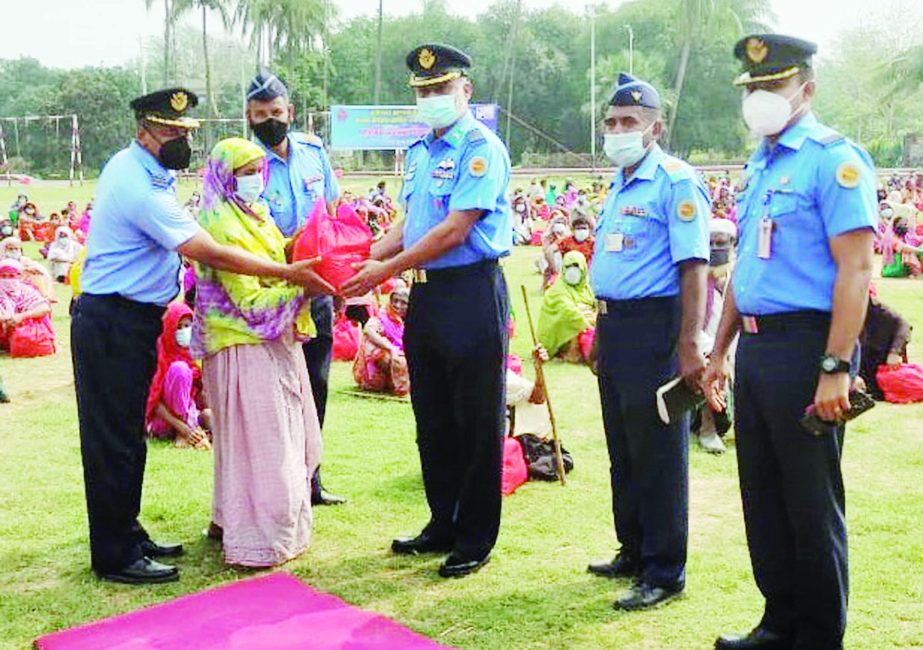 Officials of Bangladesh Air Force distribute relief materials among the 508 helpless families at Bangabandhu Air Base, Kurmitola, in the capital on Sunday. Photo ISPR