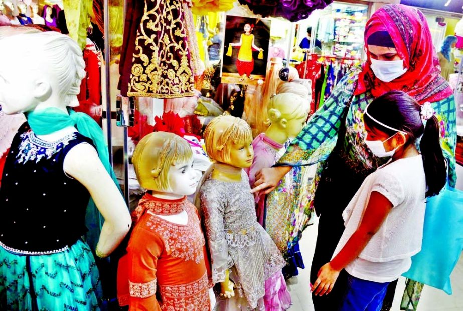 A woman along with her little girl looks for new dress ahead of Eid-ul-Fitr at Basundhara City Shopping Complex in the capital on Sunday.