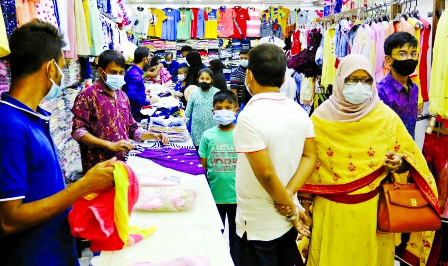 A salesman displaying children’s wear at a shop at Basundhara City Shopping Complex in the capital on Monday.