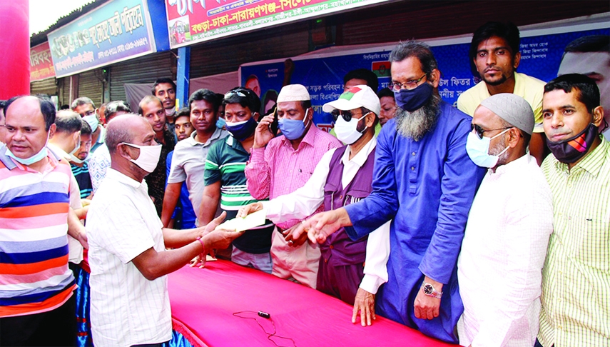Md. Helaluzzaman Talukder Lalu, member of the Adviser Panel of BNP Chairperson Begum Khaleda Zia, provide cash aid to the transport workers on behalf of Golam Mohammad Shiraj, MP at Inter-district bus stand in Bogura on Tuesday.