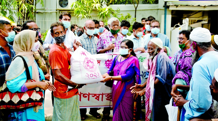 Trustee of Ganoswasthya Kendra Dr. Zafrullah Chowdhury, among others, at the foodstuff distribution among the destitute in front of Ganoswasthya Kendra in the city on Friday.