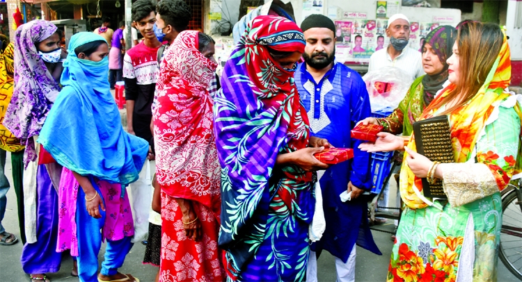 Leader of Jatiyatabadi Sangskritik Sangsad Farzana Akhter Parul distributes iftar among the pedestrians organised by the sangsad in the city's Tikatuli area on Friday.