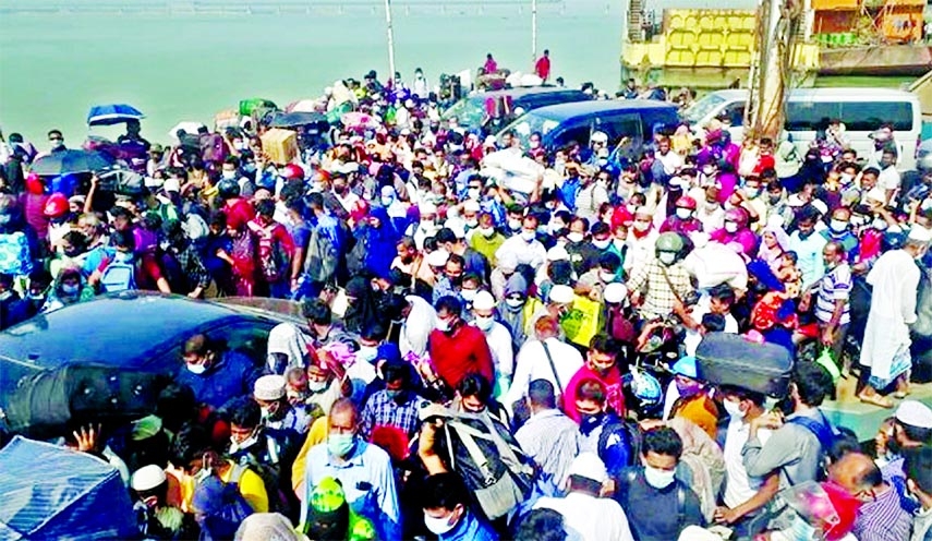 Flouting Covid health safety guidelines, passengers cram into a ferry on their way to village homes at Shimulia Ghat in Munshiganj's Louhajang upazila on Friday ahead of Eid-ul-Fitr.