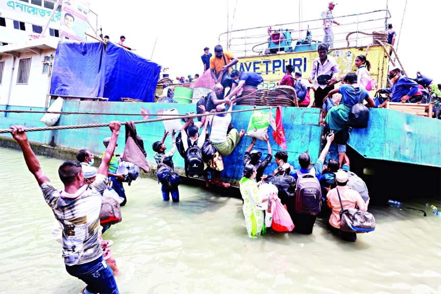 People take risk to board on a ferry in a mad rush to celebrate Eid with their near and dear ones at village home amid the ongoing lockdown to prevent spread of corona virus. This photo was taken from Shimulia Mawaghat on Saturday.